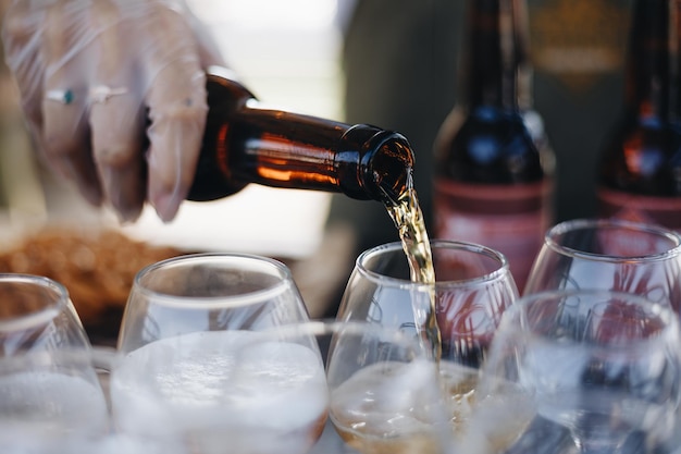 Seção intermediária do barman derramando cerveja em um copo no balcão de bar