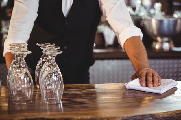 Seção intermediária do barman, limpando um balcão de bar