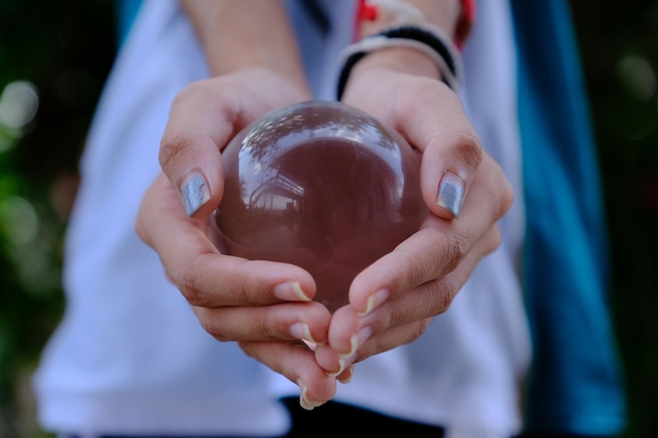 Foto seção média da mão de uma mulher segurando uma bola de cristal