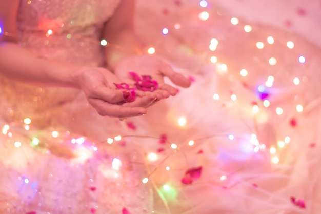 Foto seção média da noiva com luzes iluminadas segurando flores