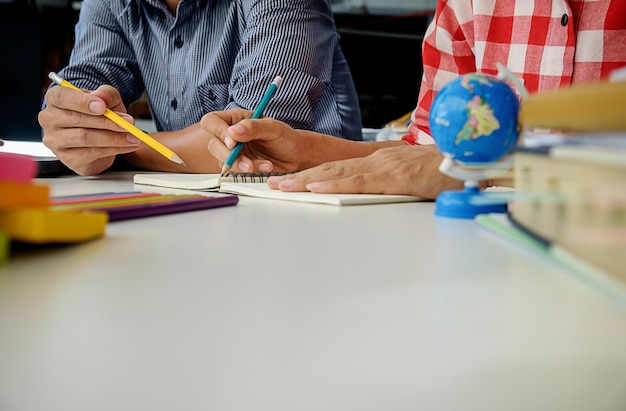 Foto seção média de amigos a estudar à mesa.