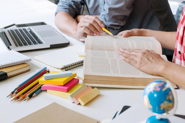 Foto seção média de amigos a estudar à mesa.