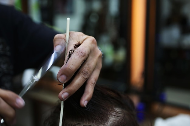 Seção média de barbeiro cortando cabelo de homem
