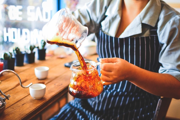 Seção média de barista fazendo café em um café