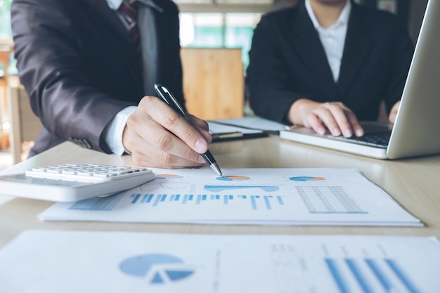 Seção média de empresários a discutir gráficos numa reunião no escritório