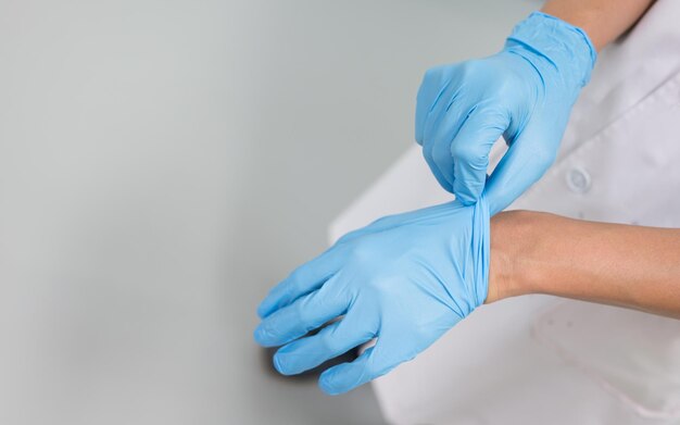 Seção média de enfermeira usando luvas em hospital
