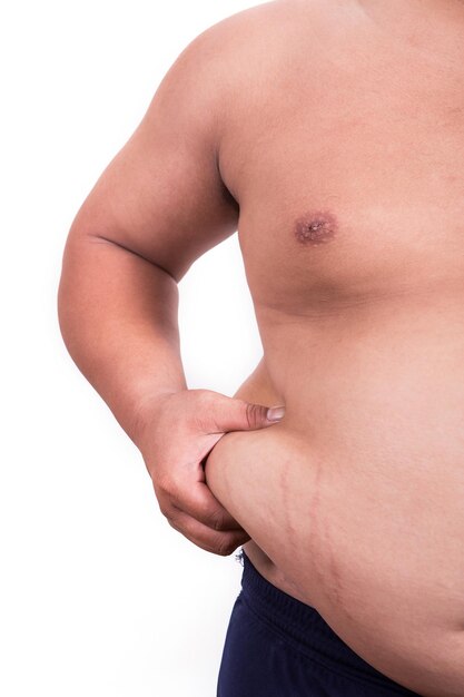 Foto seção média de homem com sobrepeso segurando o abdômen contra fundo branco