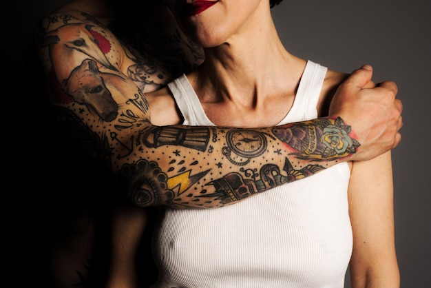 Seção média de homem tatuado mão sobre mulher contra fundo preto