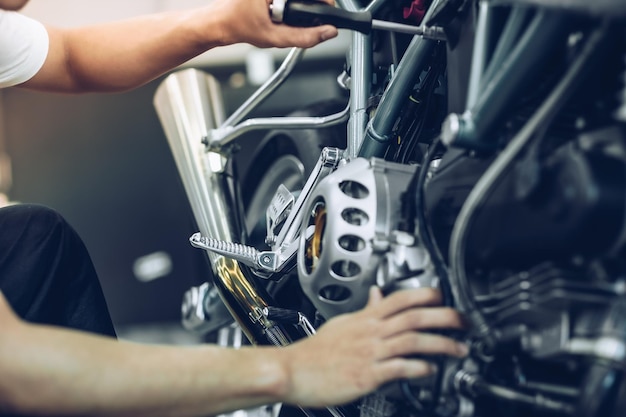 Foto seção média de mecânico reparando motocicleta na garagem