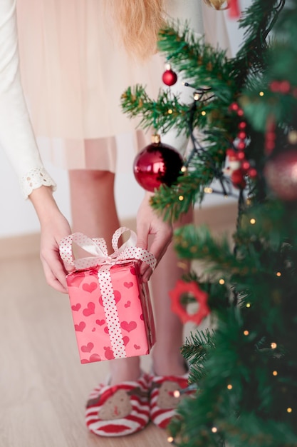 Seção média de mulher com árvore de Natal em casa