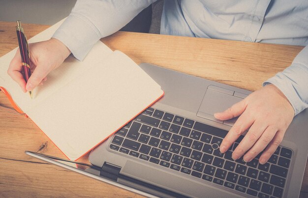 Foto seção média de mulher de negócios usando laptop na mesa no escritório