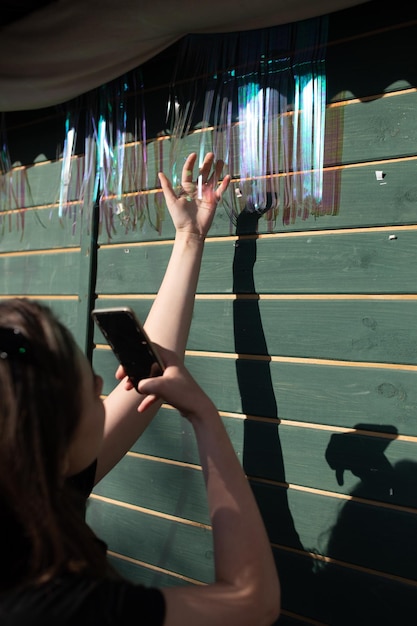 Foto seção média de mulher fotografando através de telefone inteligente na janela