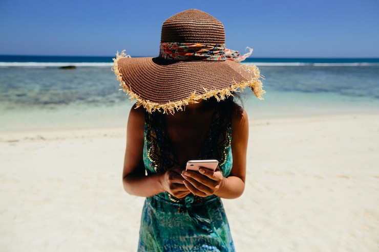 Foto seção média de mulher fotografando na praia