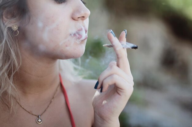 Foto seção média de mulher fumando maconha