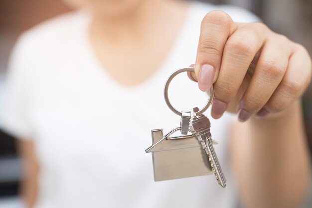 Foto seção média de mulher segurando a chave da casa