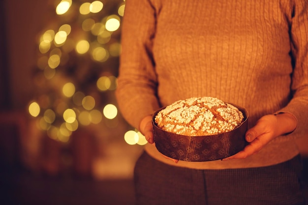 Foto seção média de mulher segurando biscoitos de natal na mesa