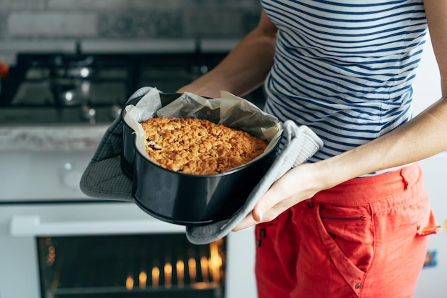 Foto seção média de mulher segurando comida em casa