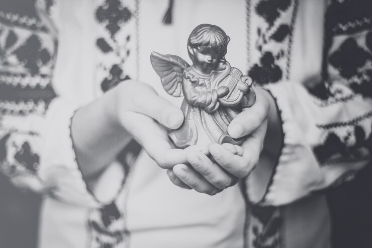 Foto seção média de mulher segurando escultura de anjo