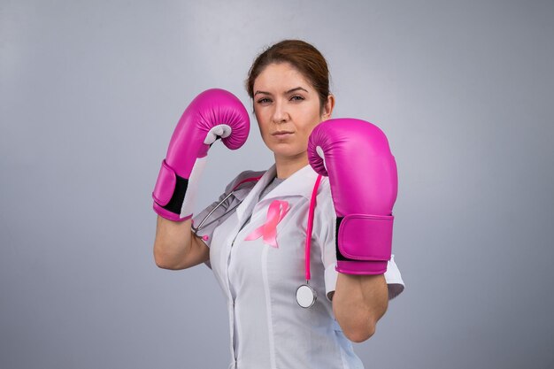 Foto seção média de mulher segurando luvas de boxe vermelhas contra fundo branco