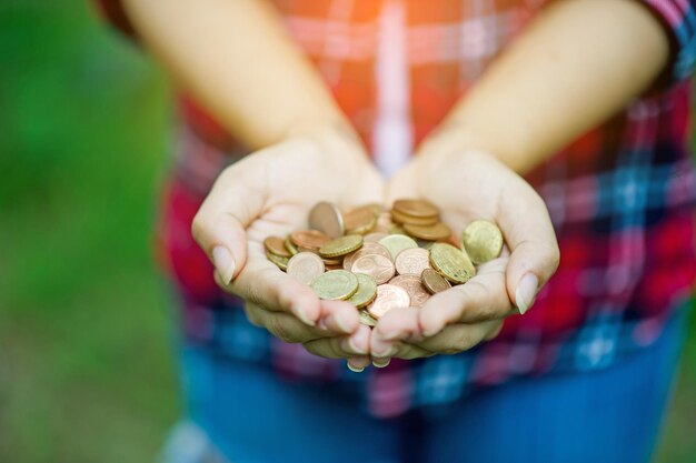 Foto seção média de mulher segurando moedas no parque