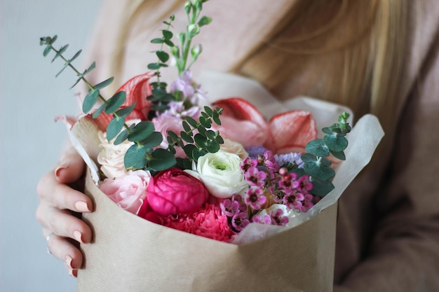 Seção média de mulher segurando um buquê de flores