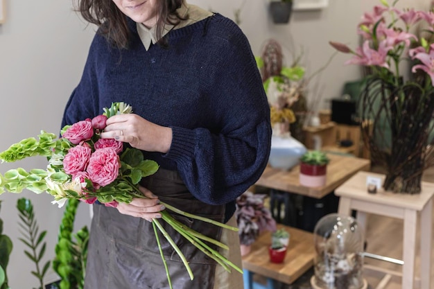 Seção média de mulher segurando um buquê de flores