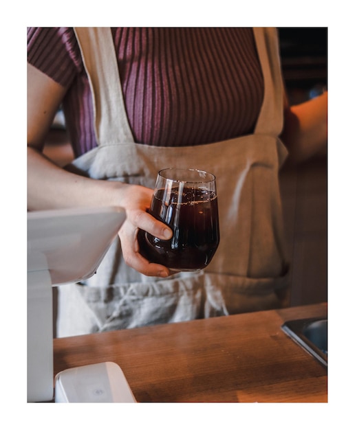 Foto seção média de mulher segurando um copo de vinho na mesa