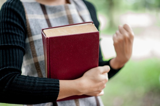 Foto seção média de mulher segurando um livro ao ar livre