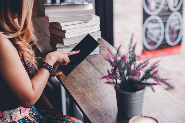 Foto seção média de mulher segurando um livro em um café