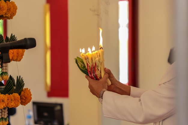 Foto seção média de mulher segurando velas acesas no templo