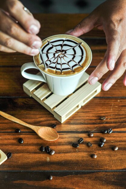 Foto seção média de mulher segurando xícara de café na mesa