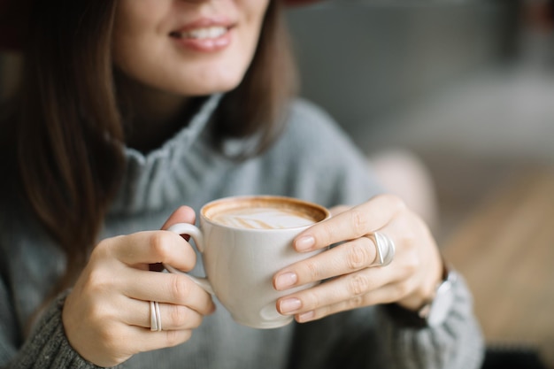 Seção média de mulher segurando xícara de café