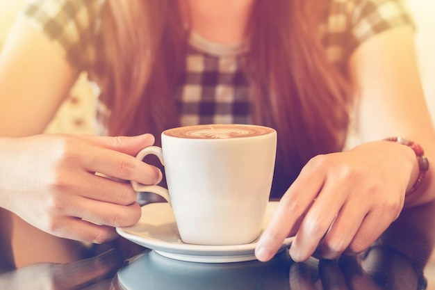 Seção média de mulher segurando xícara de café
