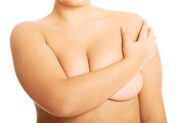 Seção média de mulher sem camisa tocando o peito sobre fundo branco