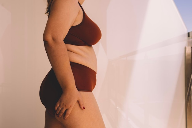 Seção média de mulher sensual em lingerie enquanto está de pé contra a parede