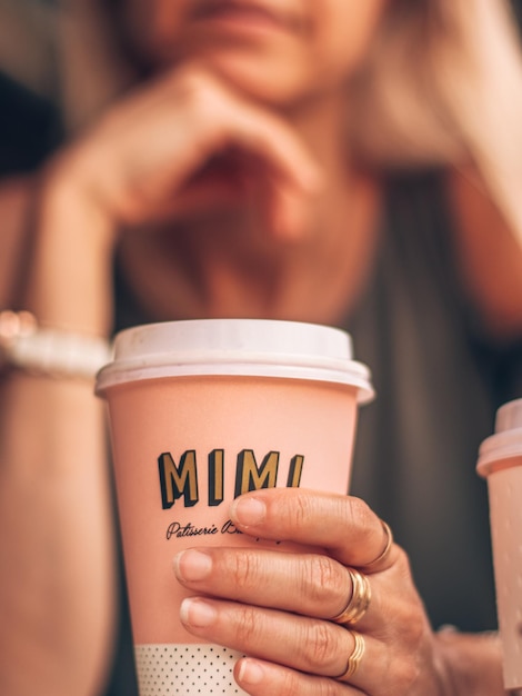 Seção média de mulher tomando café em copo descartável