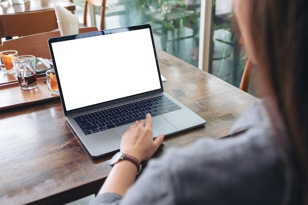 Seção média de mulher usando laptop em um café