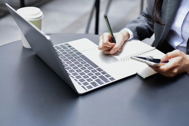 Seção média de mulher usando laptop na mesa no escritório