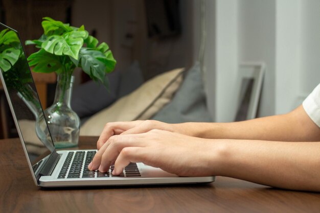 Seção média de mulher usando laptop na mesa