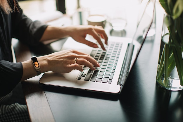 Seção média de mulher usando laptop na mesa