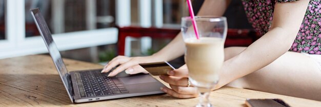 Seção média de mulher usando laptop na mesa