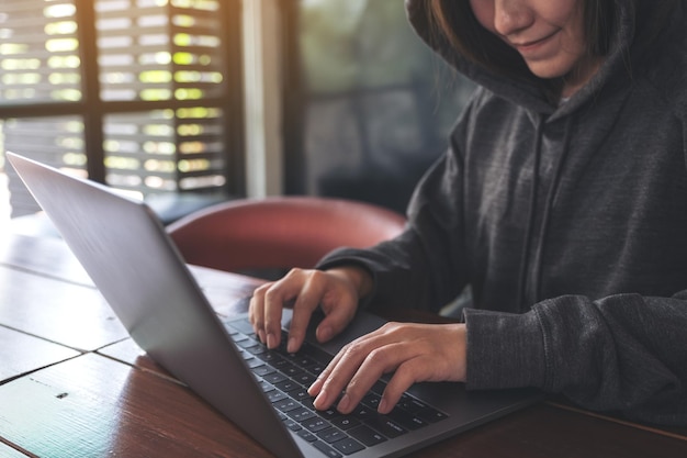 Seção média de mulher usando laptop na mesa