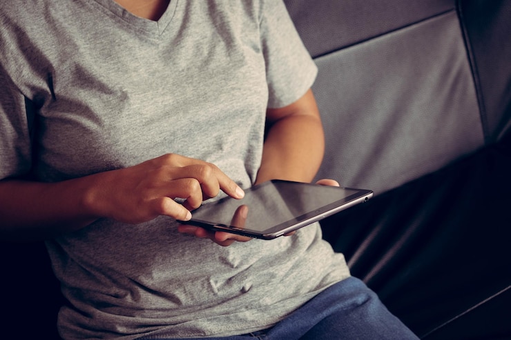 Foto seção média de mulher usando tablet digital em casa
