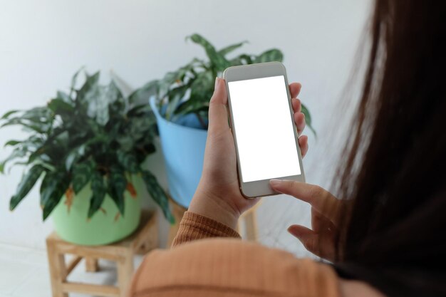 Seção média de mulher usando telefone celular em casa