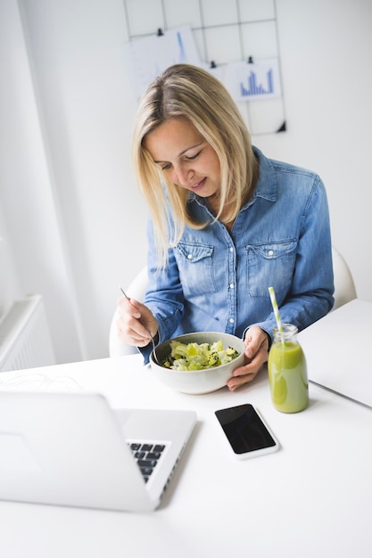 Foto seção média de mulher usando telefone enquanto está sentada na mesa