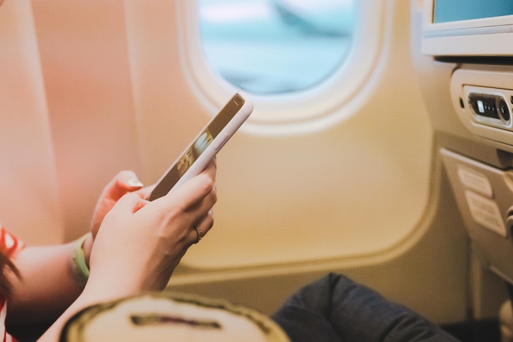 Foto seção média de mulher usando telefone móvel enquanto está sentada no avião