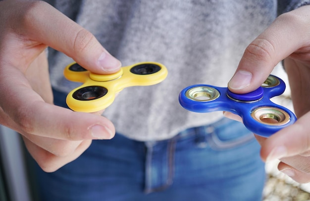 Foto seção média de mulheres segurando spinners fidget amarelos e azuis