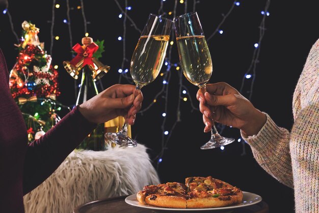 Seção média de pessoas brindando com bebidas durante o natal