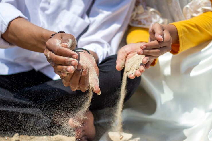 Foto seção média de pessoas derramando areia no chão