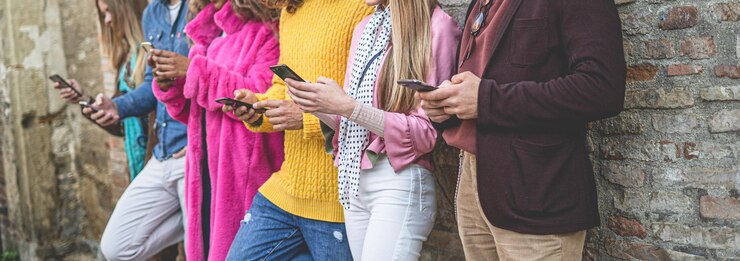 Foto seção média de pessoas usando telefones inteligentes contra a parede